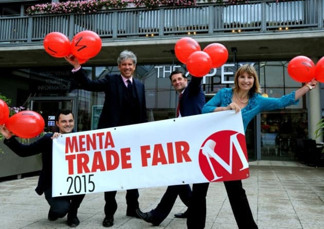 Staff members of Menta holding balloons at the trade fair we attended as a website design company